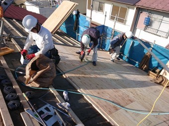 岩出市の屋根の葺き替えを行うのに野地板の下地を張り付け上から野地板を貼っていく様子の写真