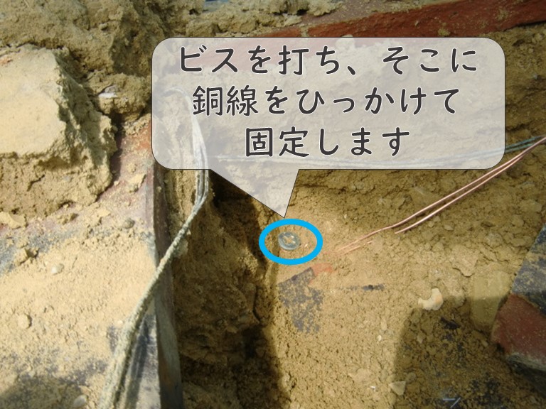 和歌山市で鬼瓦を設置するのに鬼瓦を銅線で固定し、銅線の先はビスにひっかけます