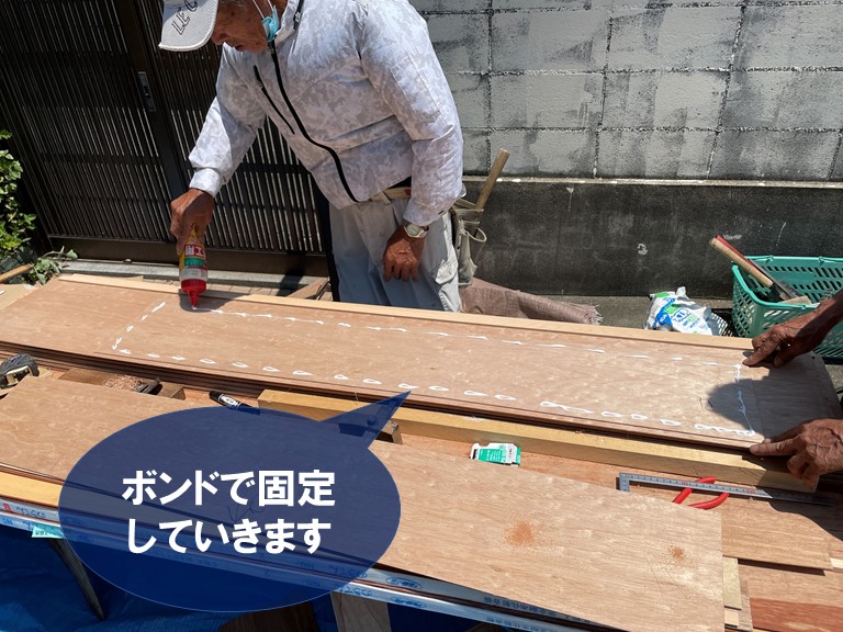 和歌山市の玄関庇の天井に無垢板をボンドで張り付けていきます